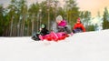 Kids sliding on sleds down snow hill in winter Royalty Free Stock Photo