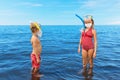 Funny kids in surgical face mask on sea beach