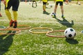 Kids soccer players moving speed tests and jogging and jumping between hula hoops for football training Royalty Free Stock Photo