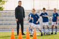 Kids in soccer team on practice session with young coach