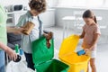 Kids sorting garbage near mother and