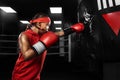 Kids sport concept. Girl sportsman muay thai boxer fighting in gloves in boxing gym.