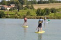 kids on a stand paddle on the pond of the leisure center of Jonzac