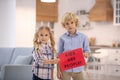 Kids standing next to each other, holding sign