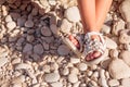 Kids summer sandals. baby shoes on stones beach. girl white fashion footwear, leather sandal ,moccasins.legs of Royalty Free Stock Photo