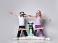 Kids in sun visors and colorful casual clothes. They are smiling, doing splits, holding spreaded hands posing isolated on white Royalty Free Stock Photo