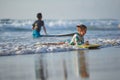 Kids surf. Little girl in beach wave. Child trying to ride body board. Preschooler surfer during training Royalty Free Stock Photo