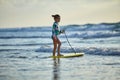 Little girl in a bright colorful swimsuit with a bodyboard A child trying to ride bodyboard