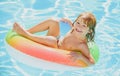 Kids Swimming with Swim Ring. Happy kid playing with colorful swim ring in swimming pool on summer day. Child water toys Royalty Free Stock Photo