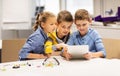 Kids with tablet pc programming at robotics school Royalty Free Stock Photo