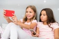 Kids taking selfie in bedroom. Pajamas party concept. Girlish leisure happy childhood. Girls long hair with smartphones