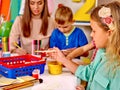 Kids with teacher holding colored paper and glue Royalty Free Stock Photo