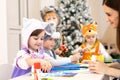 Kids with teacher make hands crafts in kindergarten. Children prepare to christmas. Group orf preschoolers on lesson in Royalty Free Stock Photo