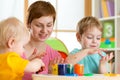 Kids with teacher painting in playschool