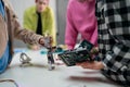 Kids with teacher working together on project with electric toys and robots at robotics classroom, close-up Royalty Free Stock Photo