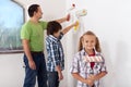 Kids and their father painting a room