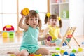 Kids toddler and preschooler girls play logical toy learning shapes, arithmetic and colors at home or kindergarten