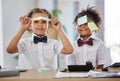 Kids, together and playing office with sticky note in portrait with happiness, brainstorming and teamwork. Siblings Royalty Free Stock Photo