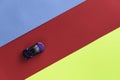 Kids toy car on trendy colorful background. Baby car top view on blue red yellow colored paper. Boys game. Travel and Royalty Free Stock Photo