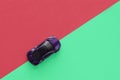 Kids toy car on trendy colorful background. Baby car top view on green and pink colored paper. Boys game. Travel and Royalty Free Stock Photo