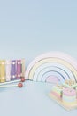 Kids toys collection. Wooden rainbow, educational and music baby toys on light blue background