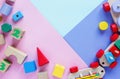 Kids toys: pyramid, wooden blocks, bear, train frame on colored background. Top view. Flat lay. Royalty Free Stock Photo