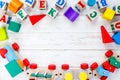 Kids toys: pyramid, wooden blocks, train frame on white wooden background. Education, games for preschool. Top view. Flat lay.