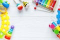 Kids toys: pyramid, wooden blocks, xylophone, train on white wooden background. Top view. Royalty Free Stock Photo