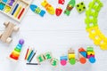 Kids toys: pyramid, wooden blocks, xylophone, train on white wooden background. Top view. Flat lay. Copy space Royalty Free Stock Photo