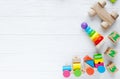 Kids toys: pyramid, wooden blocks, xylophone, train on white wooden background. Top view. Flat lay. Copy space