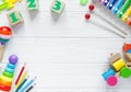 Kids toys: pyramid, wooden blocks, xylophone, train on white wooden background. Top view. Flat lay.