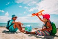 Kids travel on beach, boy and girl with globe and toy plane Royalty Free Stock Photo