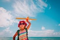 Kids travel on beach, cute girl with backpack and toy plane at sea Royalty Free Stock Photo