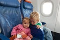 Kids travel by plane - little boy and toddler girl in flight Royalty Free Stock Photo