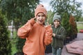 Kids in trendy hats and hoodies having fun in park, fall vibes, autumn beauty style, child fashion Royalty Free Stock Photo