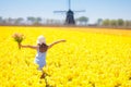 Kids in tulip flower field. Windmill in Holland Royalty Free Stock Photo