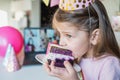 Kids virtual birthday,home party.Girl eating piece of cake.Online conference,video call in laptop,computer.Friends on screen, Royalty Free Stock Photo