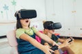 Kids in virtual reality headsets playing video game at home Royalty Free Stock Photo