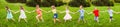 Kids walking on grass hill holding hands at sunny day Royalty Free Stock Photo