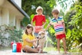 Kids wash dog in summer garden. Water hose fun Royalty Free Stock Photo