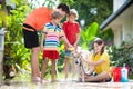 Kids wash dog in summer garden. Water hose fun Royalty Free Stock Photo