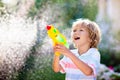 Kids with water gun toy in garden. Outdoor fun Royalty Free Stock Photo