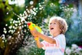 Kids with water gun toy in garden. Outdoor fun Royalty Free Stock Photo