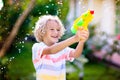 Kids with water gun toy in garden. Outdoor fun Royalty Free Stock Photo