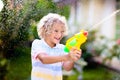 Kids with water gun toy in garden. Outdoor fun Royalty Free Stock Photo