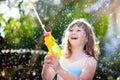 Kids with water gun toy in garden. Outdoor fun Royalty Free Stock Photo