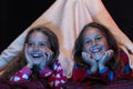 Kids wearing red jammies watching TV in blanket tent