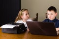 Kids working on old typewriter and laptop