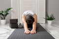 Child`s Pose. meditation. . children yoga at home. boy wearing gray clothes sitting on a gray yoga mat in a white light