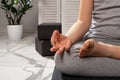 Kids yoga at home. namaste . jnana mudra. boy wearing gray clothes sitting on a gray yoga mat in a white light room